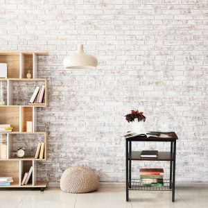 Interior of modern room with bookcase, pouf and lamp