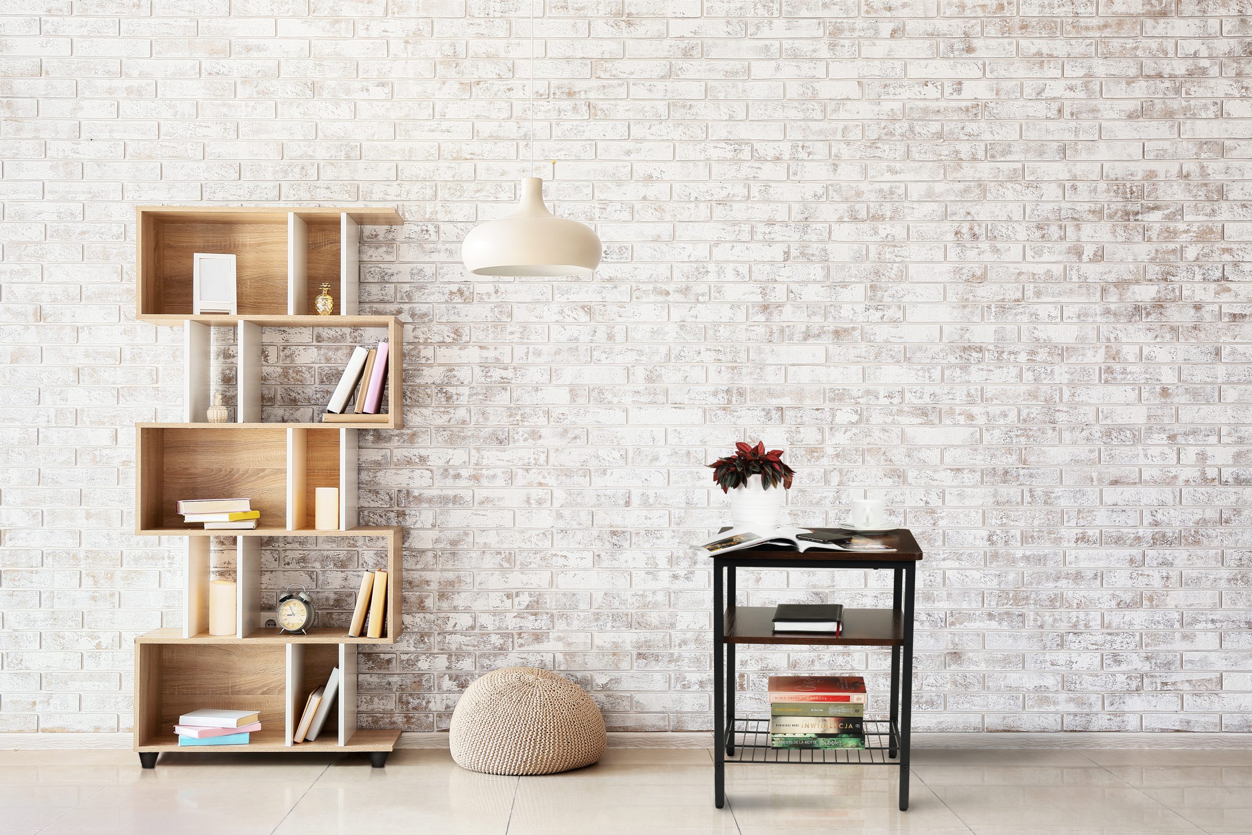 Interior of modern room with bookcase, pouf and lamp