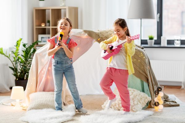 girls with guitar and microphone playing at home